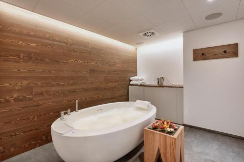 英格堡恩格尔伯格H+温泉酒店 的浴室配有白色浴缸和木墙