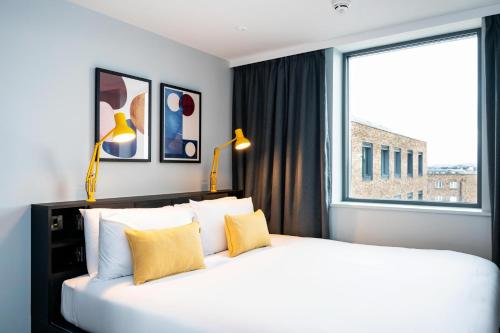 都柏林Staycity Aparthotels Dublin Tivoli的一间卧室设有一张大床和大窗户
