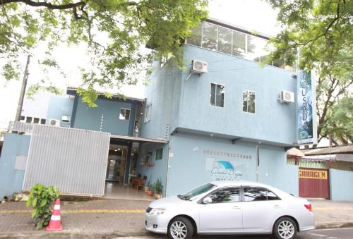 伊瓜苏科德斯道瓜旅馆的停在蓝色建筑前的白色汽车