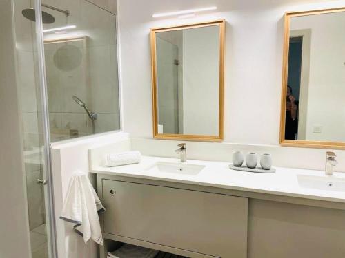 Poste LafayetteEast Coast Beachfront Luxury - Eastern Blue Apartments的白色的浴室设有2个盥洗盆和淋浴。