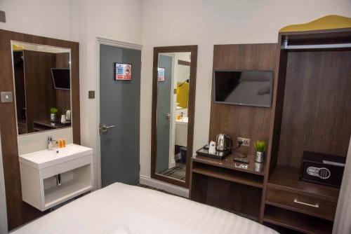 伦敦霍德华温切斯特酒店的浴室设有床、水槽和镜子