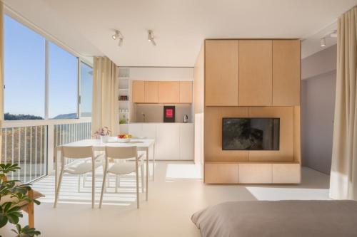 新戈里察Elegant Studio Apartment with Panoramic View的厨房以及带桌椅的起居室。