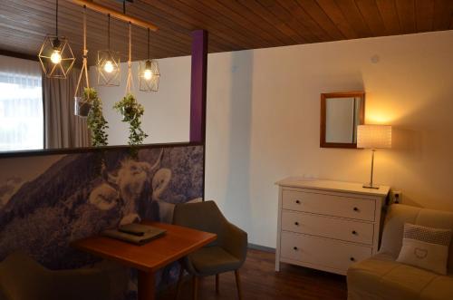 滨湖采尔Dahoam by Sarina - Rooms & Suites的客厅配有桌椅和梳妆台