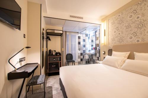 巴黎ELSA, Hôtel Paris的一间酒店客房,配有一张白色的床和一张书桌