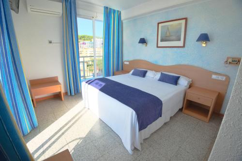 卡里拉因特纳克纳尔酒店的一间卧室配有一张带蓝色墙壁的大床
