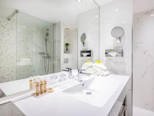 尼斯尼斯海滨酒店的白色的浴室设有水槽和镜子