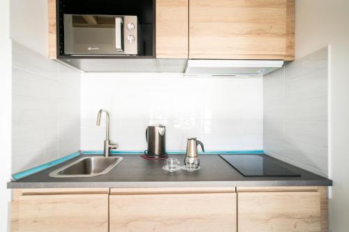 布勒伊-切尔维尼亚Stay in Cervinia Deluxe Apartment的厨房配有水槽和微波炉