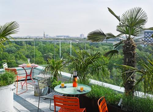 柏林柏林比基尼25小时酒店的阳台的天井配有2张桌子和椅子