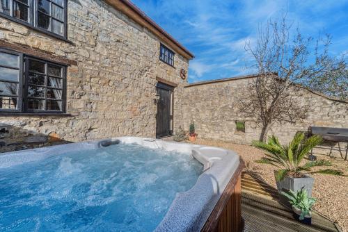 Hatch BeauchampSomerset Country Escape - Luxury barns with hot tubs的一座位于大楼旁的院子内的热水浴池