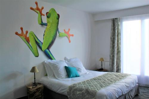 拉帕尔米雷Au Palmyre Hôtel的卧室配有一张床上,墙上挂着青蛙