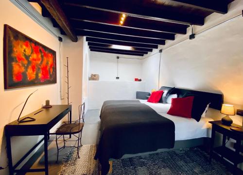 UgaFinca Curbelo的一间卧室配有一张带红色枕头的床和一张书桌