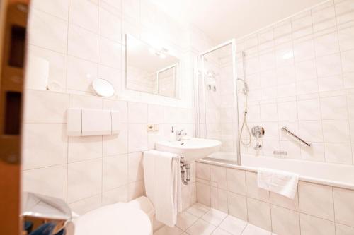 加尔米施-帕滕基兴Kreuzeck的白色的浴室设有水槽和浴缸。