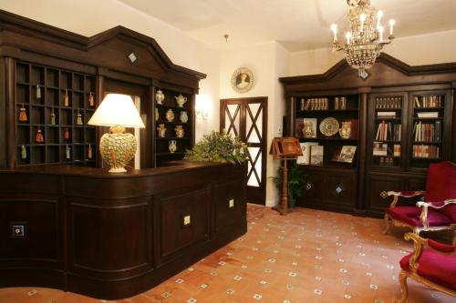 尼科洛西多拉塔别墅酒店的一间设有图书馆的房间,配有木柜和灯