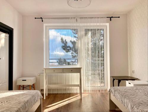 MęcinaMore Home Cycling的一间卧室设有两张床和一个美景窗户。