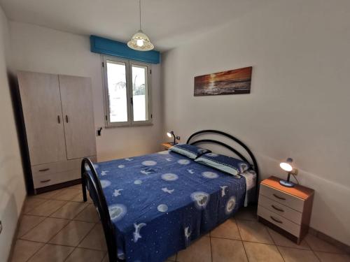 托雷圣乔万尼乌Appartamento Ghirigoro 1的一间卧室配有一张带蓝色棉被的床