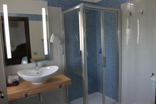 圣玛丽亚纳瓦雷地中海酒店的一间带水槽和玻璃淋浴的浴室