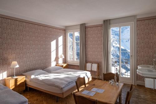 米伦雷吉纳酒店的卧室配有床、桌子和窗户。