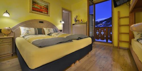 利维尼奥皮克罗蒙德酒店的一间卧室设有一张大床和一个大窗户