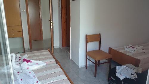 科斯镇维罗尼基酒店的小房间设有一张床和一把椅子