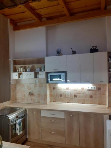考波什堡Adél Apartman的厨房配有白色橱柜和微波炉