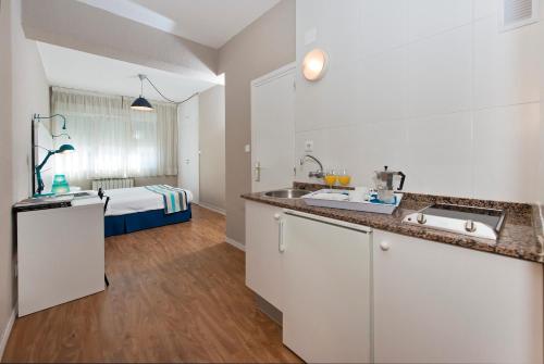 桑坦德阿兰萨苏一室公寓酒店的一个带水槽的厨房和一张位于客房内的床