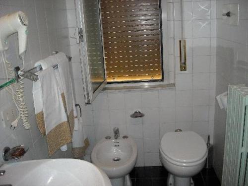米兰维也纳酒店的白色的浴室设有卫生间和水槽。