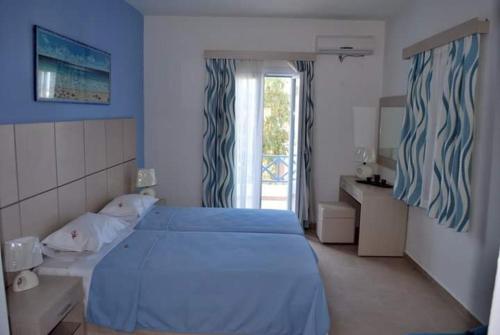 阿佐里姆诺斯Thealos的一间卧室设有蓝色的床和窗户。