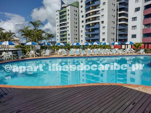 马蒂尼奥斯Apto Cond Ilhas do Caribe - Pr - Beira Mar的一座大型游泳池,位于部分建筑的中间