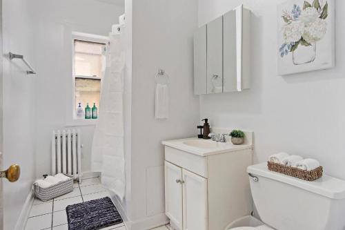 芝加哥Stylish and Expansive 2BR Apt with Balcony - Buckingham 3的白色的浴室设有卫生间和水槽。