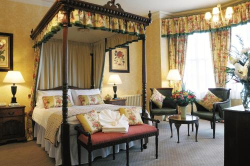 迪韦齐斯贝尔酒店 的一间卧室配有四柱床和两把椅子