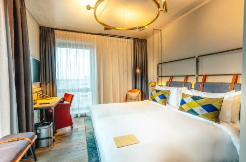 阿姆斯特丹Four Elements Hotel的酒店客房设有一张大床和一张书桌。