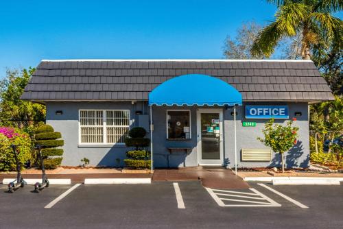 萨拉索塔SureStay Hotel by Best Western Sarasota Lido Beach的蓝色和白色的办公楼,设有停车场