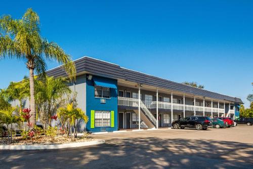 萨拉索塔SureStay Hotel by Best Western Sarasota Lido Beach的蓝色的建筑,停车场有停车位