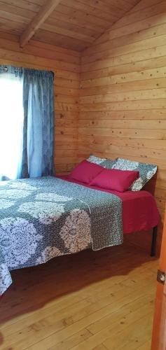 乌维塔Cabaña Tio King的小木屋内一间卧室,配有一张床