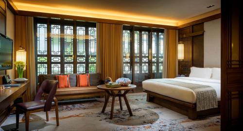 丽江丽江和府洲际度假酒店的一间卧室配有一张床、一张桌子和一张桌子