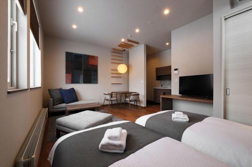 富良野Orchid Furano的酒店客房设有两张床和电视。