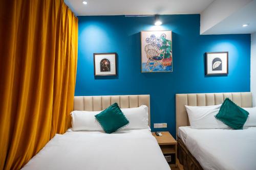 乔治市阿波罗酒店的蓝色墙壁客房的两张床