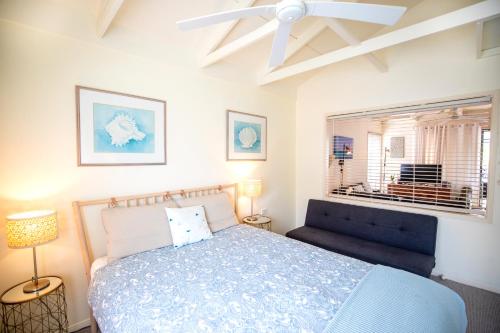 波因特卢考特THE DUNES + 100M TO BEACH + POOL + EXCEPTIONAL LOCATION的一间卧室设有蓝色的床和窗户。