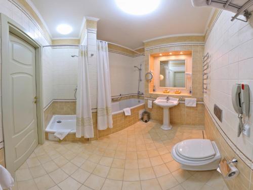波尔塔瓦阿里亚格兰德酒店的浴室配有卫生间、盥洗盆和浴缸。