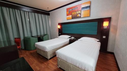 阿布扎比斯特朗德酒店的酒店客房设有两张床和窗户。