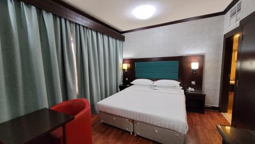 阿布扎比斯特朗德酒店的一间卧室配有一张床、一张桌子和一把椅子