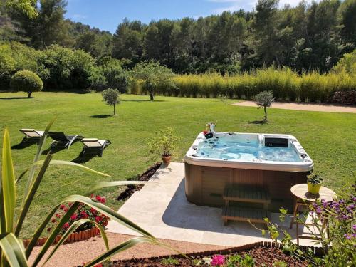 欧巴涅Les Prairies de Fenestrelle Spa & Piscine au calme的庭院中间的热水浴池