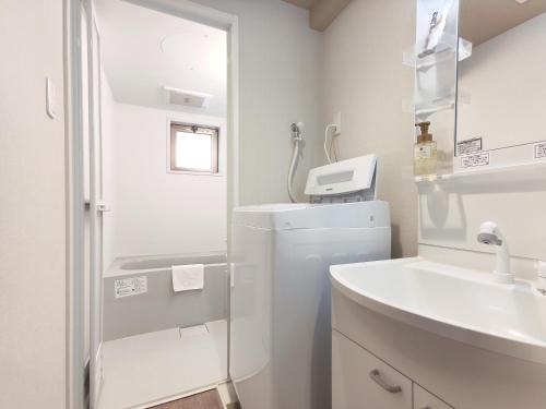 京都West Japan Kyoto Kiyomizu的白色的浴室设有水槽和冰箱。