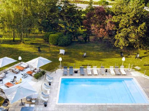 博讷诺沃特宝纳酒店的享有带椅子和遮阳伞的游泳池的上方景色