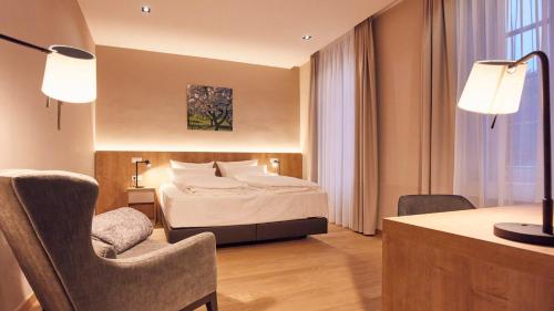 玛利亚拉赫玛利亚拉西湖滨酒店的酒店客房配有一张床、一张桌子和一把椅子。