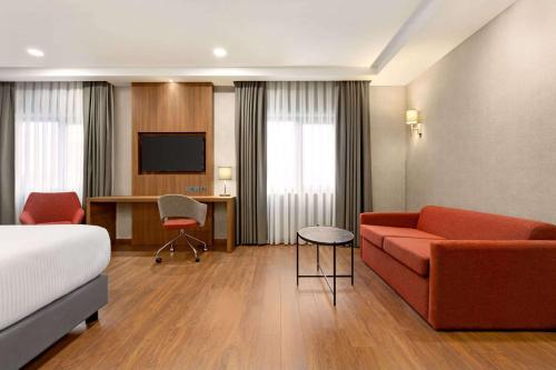 阿德亚曼Ramada by Wyndham Adiyaman的一间配备有沙发及电视的酒店客房