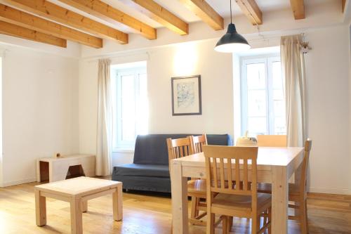 博尔戈Trentino Apartments - Il Gufo Vacanze的客厅配有桌子和蓝色沙发