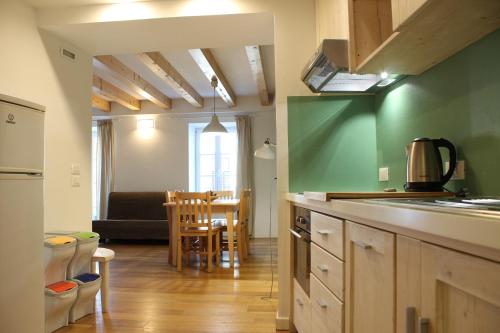 博尔戈Trentino Apartments - Il Gufo Vacanze的一间带柜台的厨房和一间餐厅