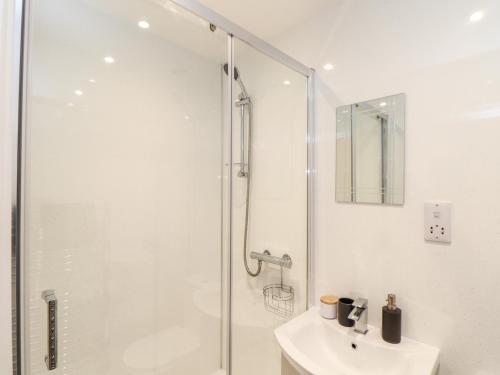 坎伯恩Battell Chambers的带淋浴和盥洗盆的白色浴室