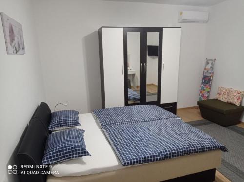 比哈奇DALMAR Apartman的一间卧室配有一张带蓝色枕头和镜子的床